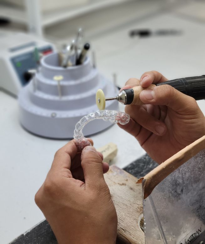 Chomper Labs lab technician polishing night guard.