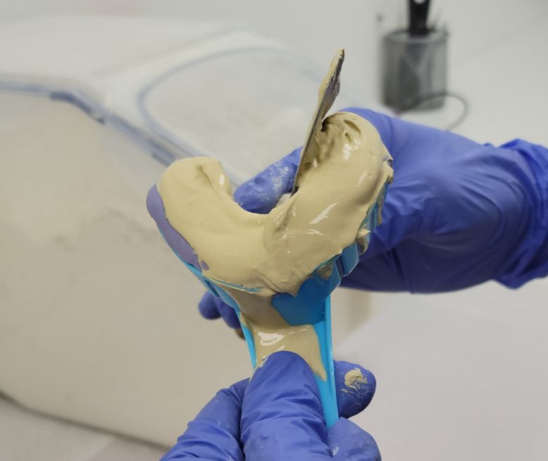 Chomper Labs lab technician pouring up model of teeth using stone.