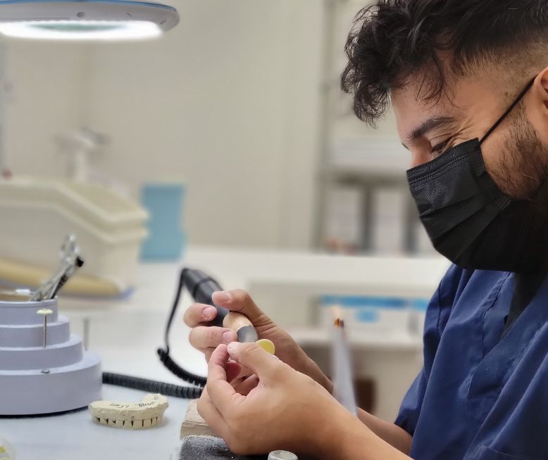Dental lab technician cutting a night guard.